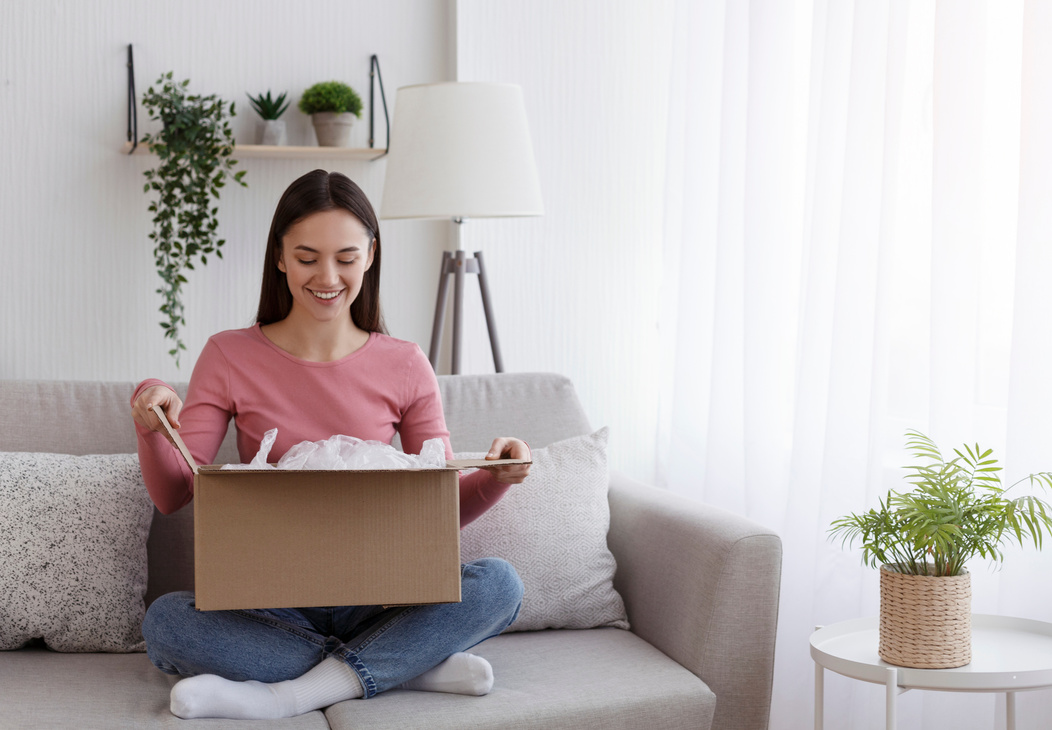 Satisfied smiling woman looking into open parcel box